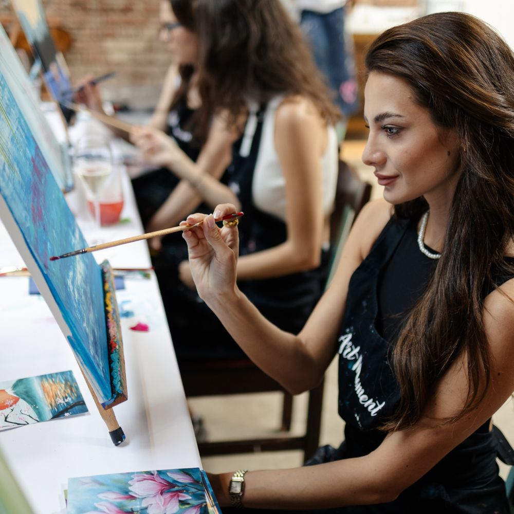 Žena maľuje na plátno v kurze maľovania ArtMoment
