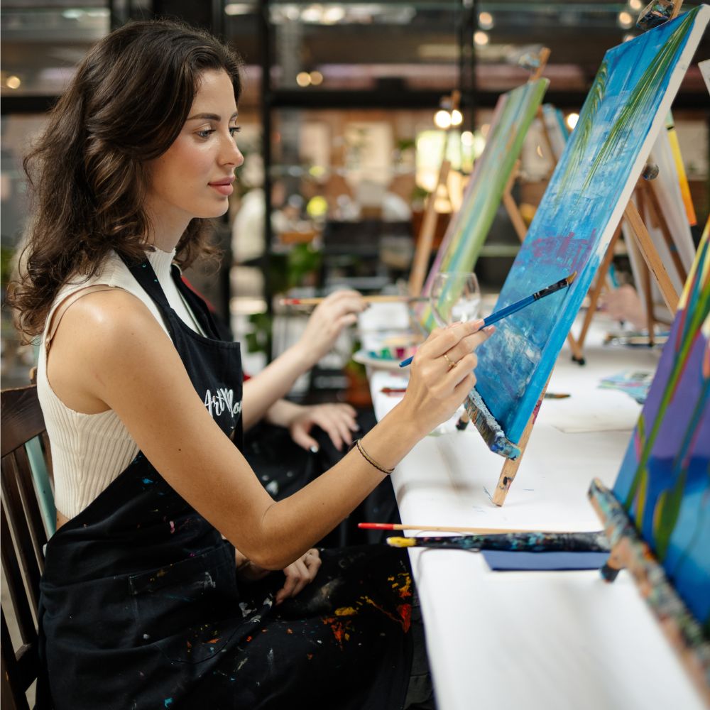 Žena maľuje na plátno v kurze maľovania ArtMoment