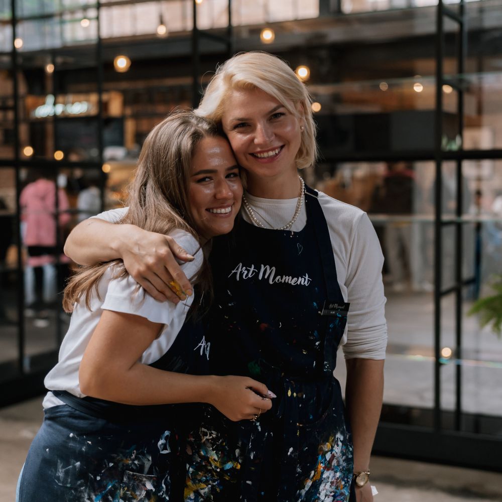 Inštruktorka a účastníčky kurzu maľovania ArtMoment sa objímajú