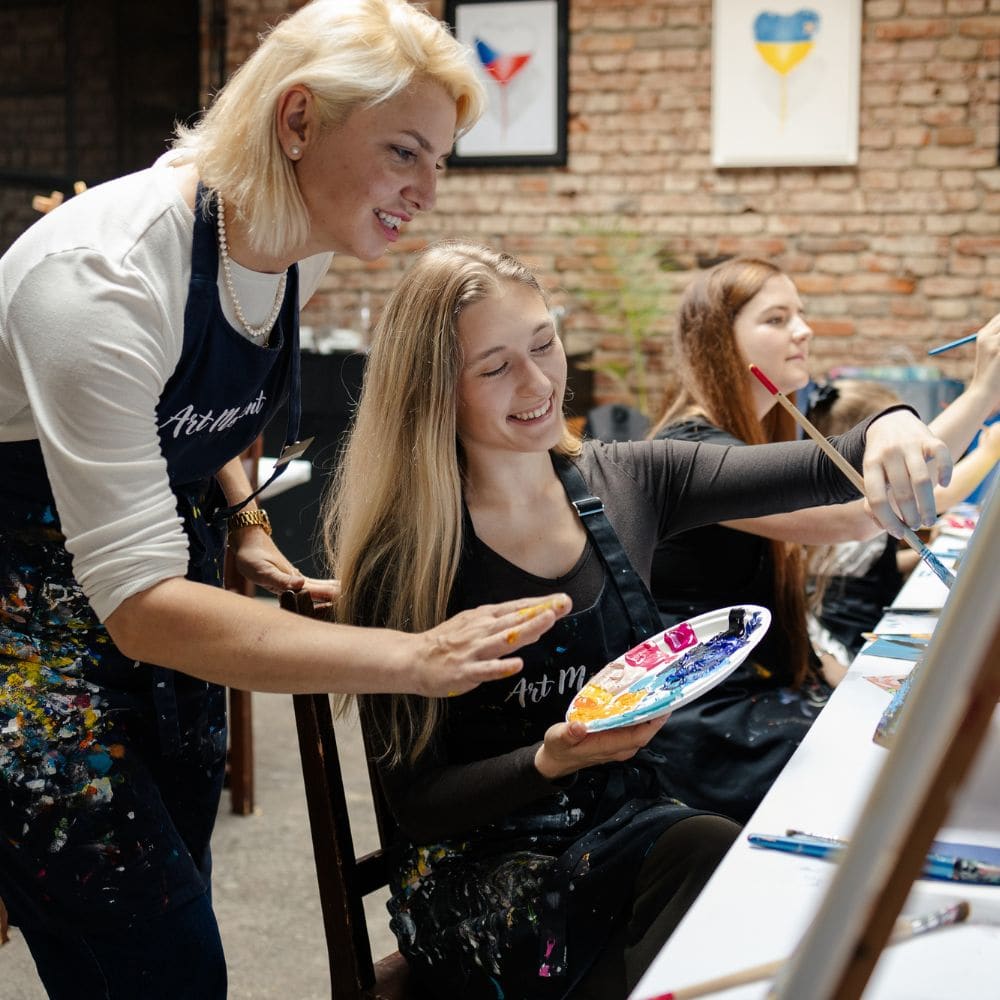 Inštruktorka pomáha účastníčke kurzu maľovania ArtMoment